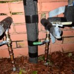 New Orleans emergency plumbing repair showing exterior pipes, hose bib connections, and water line service work by Serrano’s Plumbing Services